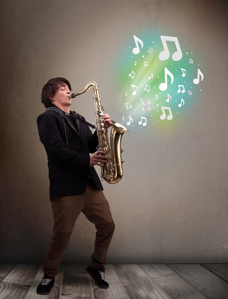 Jeune musicien jouant sur saxophone tandis que les notes de musique explosent
 - Photo, image