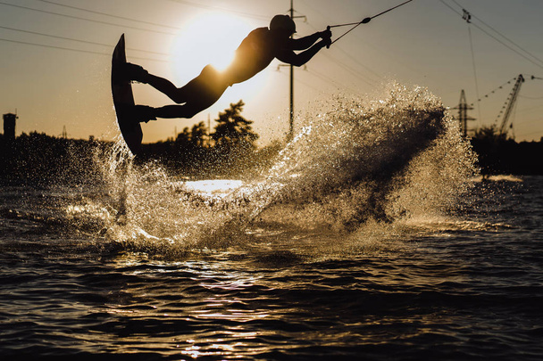 wakeboard. wakeboarden springen bij zonsondergang - Foto, afbeelding