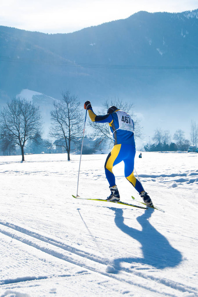 esquiador cross country com número de competição durante uma corrida em uma montanha
 - Foto, Imagem