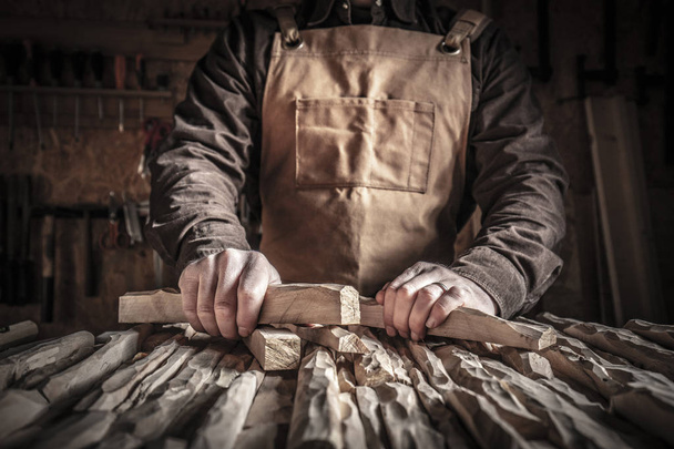 detail of carpenter holding carved wood - 写真・画像