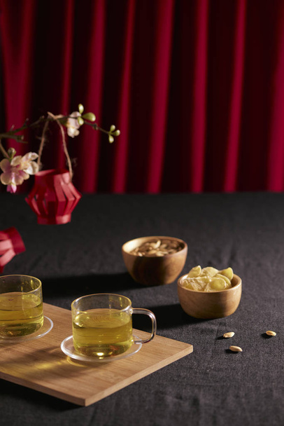 Capodanno lunare cibo e bevande su tavolo di legno scuro con ramo di ciliegia in fiore
 - Foto, immagini