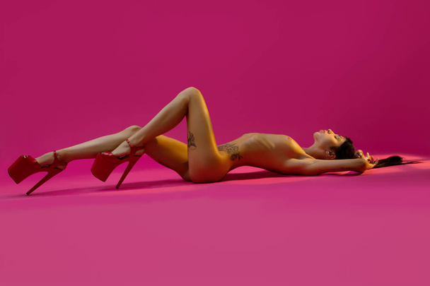 Nude woman in red high heel shoes on the floor - Fotografie, Obrázek