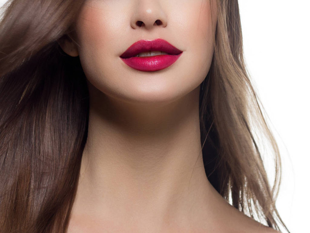 Close-up of woman's lips with fashion bright pink make-up. Beautiful female mouth, full lips with perfect makeup. Part of female face. Choice lipstick and Pink wavy hair of a doll - Foto, afbeelding