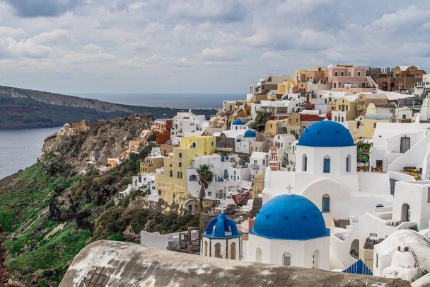 Santorini, Greece. Amazing view of Santorini nature, volcano of Santorini, traditional cycladic Santorini houses, Oia village, Fira, caldera. Traditional and famous cycladic houses and churches with blue domes over the Caldera, Aegean sea. - Foto, afbeelding