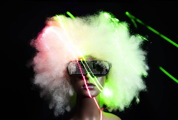 Etalagepop met zonnebril en laser verlichting op zwarte achtergrond - Foto, afbeelding
