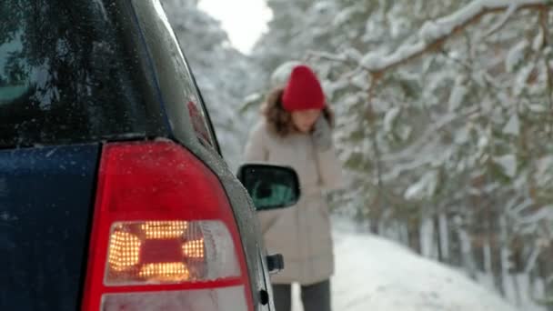 vrouw met een stro auto op de weg in de winter - Video