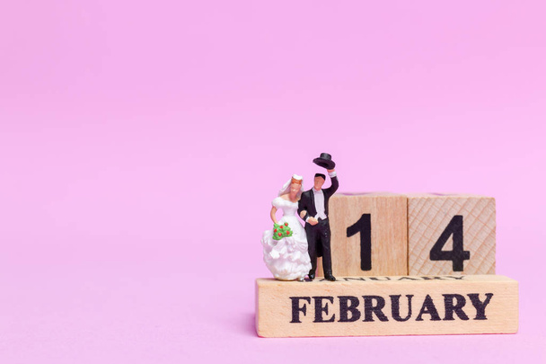 Miniature people wedding , bride and groom couple on pink  background , Valentine's Day concept - Фото, изображение