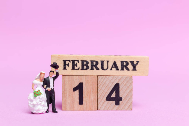 Miniature people wedding , bride and groom couple on pink  background , Valentine's Day concept - Valokuva, kuva