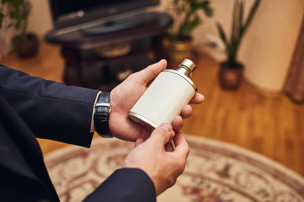Handsome guy is choosing perfumes, Elegant man in suit using cologne,groom getting ready in the morning before wedding ceremony. Men Fashion - Foto, Imagen