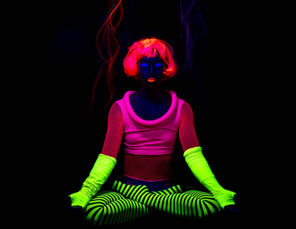 Жінка в флуоресцентному одязі, сидячи в позі лотоса
 - Фото, зображення