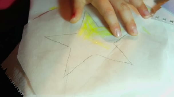 Bambina che colora una stella di carta con pennarello giallo al rallentatore. Fare decorazioni natalizie per le vacanze
. - Filmati, video