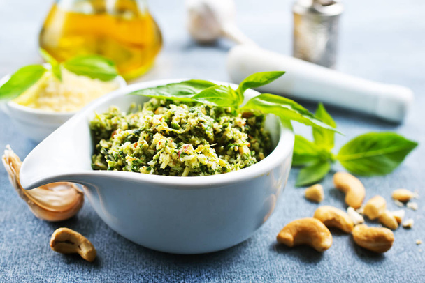close up of pesto sauce in white bowl with nuts and oil - Photo, image