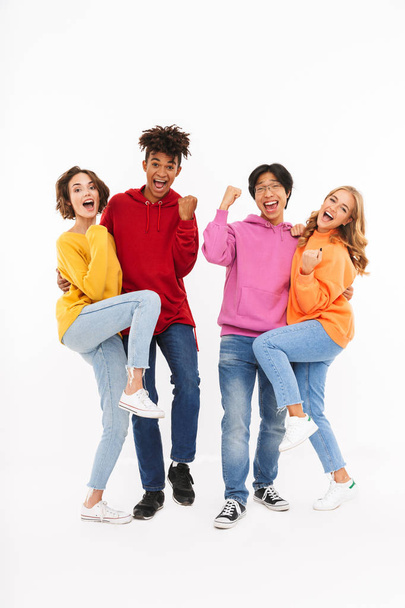 Group of cheerful teenagers isolated over white background, celebrating - Foto, Imagem