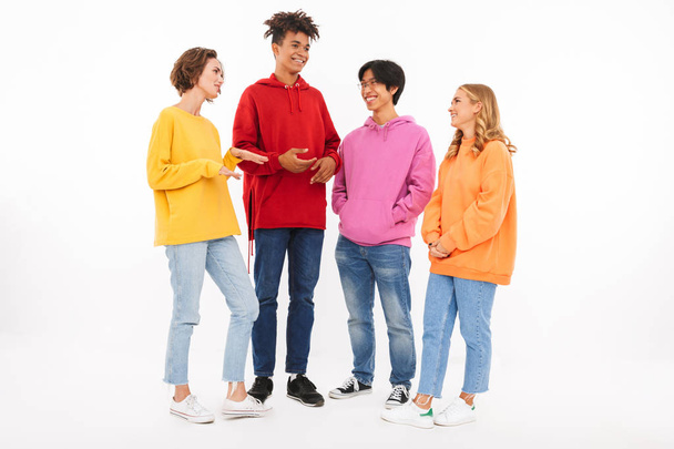 Group of cheerful teenagers isolated over white background, talking - Foto, Imagem
