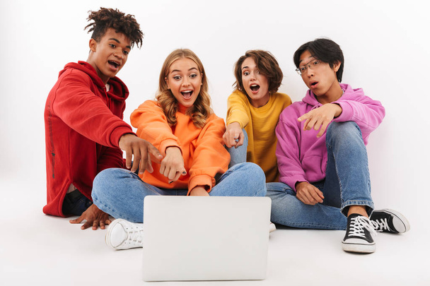 Gruppo di adolescenti allegri isolati su sfondo bianco, guardando il computer portatile, agitando
 - Foto, immagini
