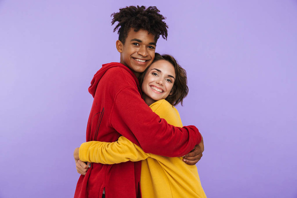 Photo of young couple friends students standing isolated over white wall background hugging. - Foto, Imagem