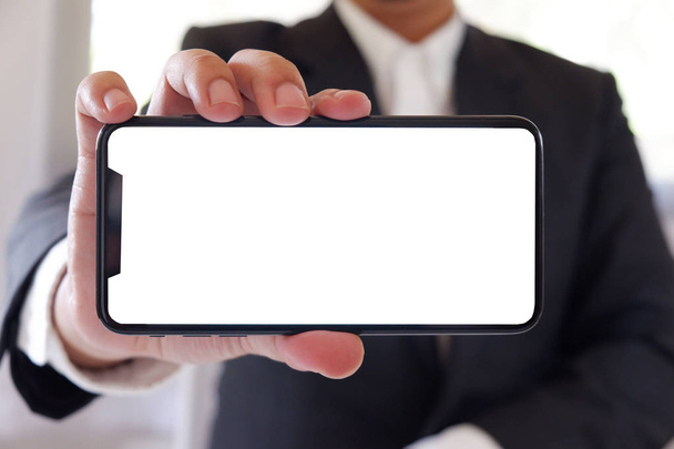 Liikemies tilalla älypuhelin eteenpäin tyhjä valkoinen ruutu tekstin tai kuvan
 - Valokuva, kuva