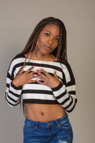Young Black Girl in striped shirt with exposed midriff posing in studio - Фото, зображення