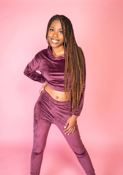 African American woman with amazing braided long hair in a casual urban lifestyle outfit on a pink backdrop - Foto, immagini