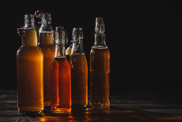 homemade traditional tea in glass bottles isolated on black - Foto, Bild