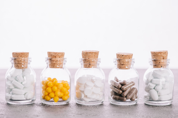palack dugók és a különböző tabletták elszigetelt fehér sor - Fotó, kép