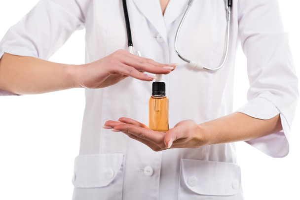 vista recortada del médico femenino sosteniendo botella con aceite de cbd aislado en blanco
 - Foto, imagen