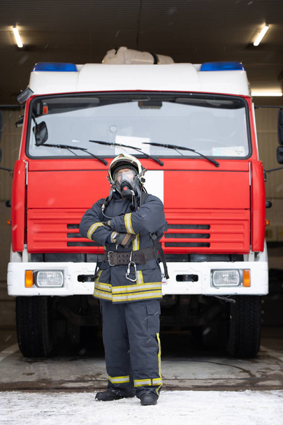Ganztägiges Foto von Mann mit Gasmaske in der Nähe von Feuerwehrauto - Foto, Bild