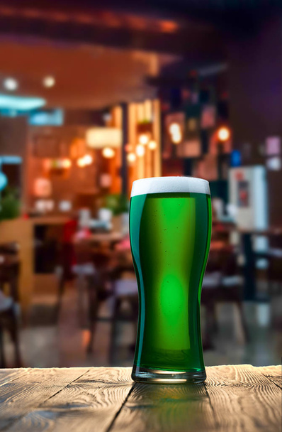 Glas frisches kaltes grünes Bier auf einem hölzernen Tresen in der Kneipe. - Foto, Bild