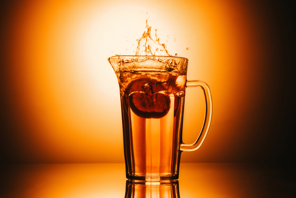 selective focus of jar with tea and lemon slice on orange background - Photo, Image