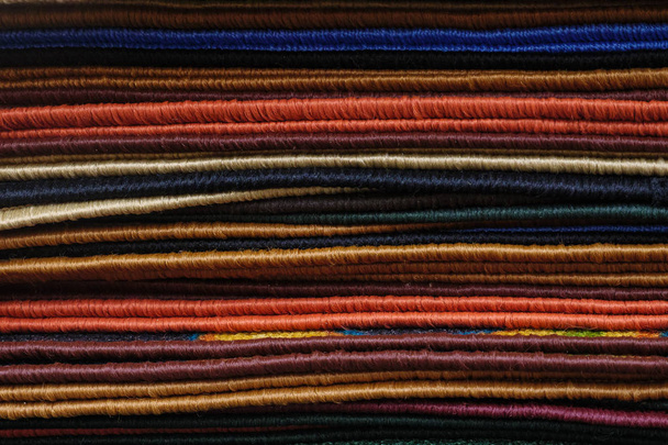 Ανάμικτες πολύχρωμα μαλακά χαλιά ξαπλωμένη σε ένα σωρό στο σύγχρονο κατάστημα - Φωτογραφία, εικόνα