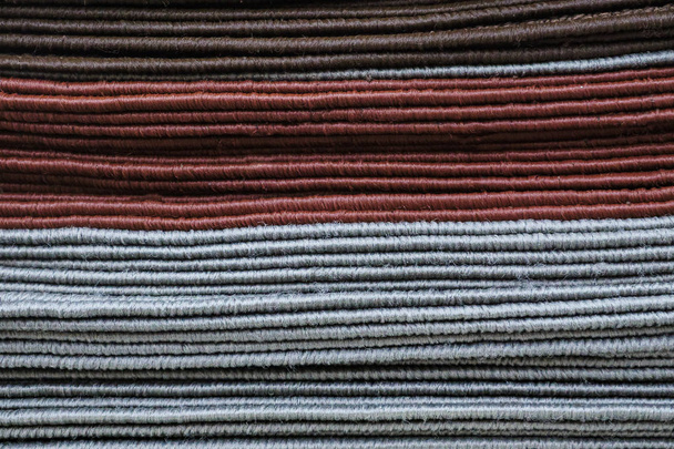 Асорті м'які килимки лежать в одній купі в сучасному магазині
 - Фото, зображення