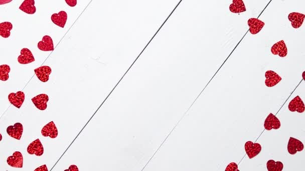 Vlentines Composición del día. Lentejuelas en forma de corazón colocadas sobre mesa de madera blanca
 - Imágenes, Vídeo