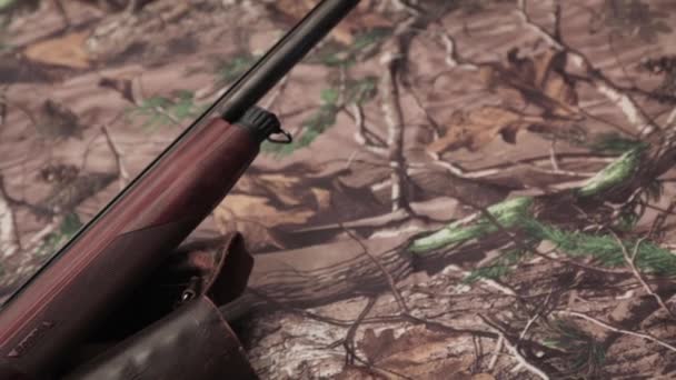Shotgun, hunter mes, cartridges en munitie gordel op de achtergrond camouflage - Video