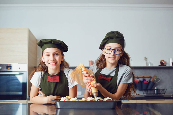 Girls children in cook uniforms in the kitchen. - Foto, Imagen
