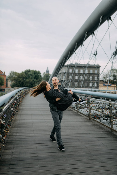 Eine Liebesgeschichte. ein Mann und eine Frau in der Nähe der Brücke. Liebesbeziehung. Herbstsonnenuntergang. - Foto, Bild