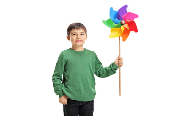 Smiling boy holding a colorful windmill toy isolated on white background - Foto, Imagen