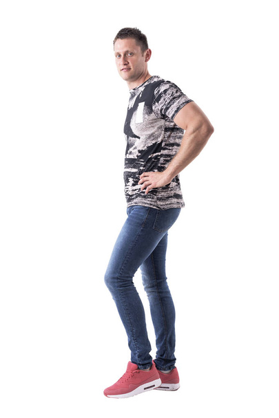 Profile view of athletic young adult man in casual clothes posing and looking at camera. Full body isolated on white background.  - Φωτογραφία, εικόνα