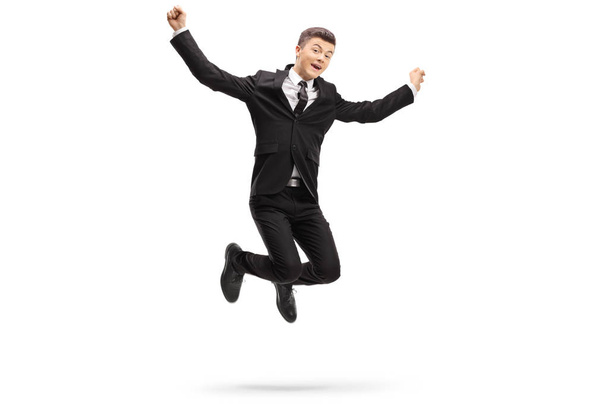 Full length portrait of an elegant young man in a suit jumping isolated on white background - Foto, imagen