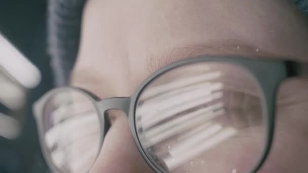 Dziewczyna z okulary oczy patrząc na kamery, extreme close-up z odbicia - Materiał filmowy, wideo