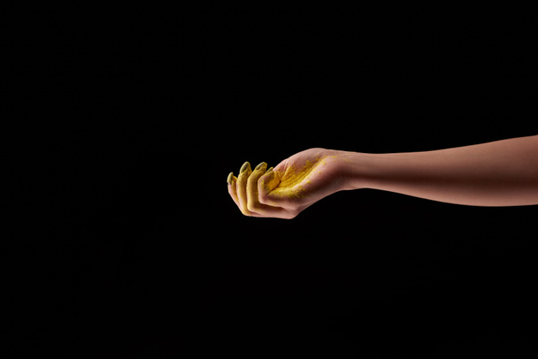 vista recortada de la mujer y el polvo de holi amarillo aislado en negro
 - Foto, Imagen