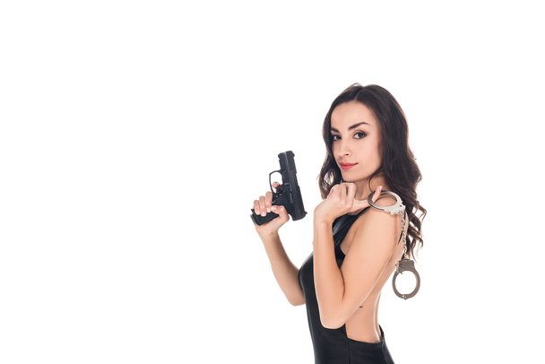 beautiful security agent in black dress holding gun and handcuffs, isolated on white - Φωτογραφία, εικόνα