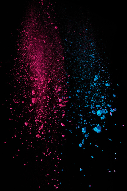  vaaleanpunainen ja sininen holi jauhe ilmassa mustalla pohjalla
 - Valokuva, kuva
