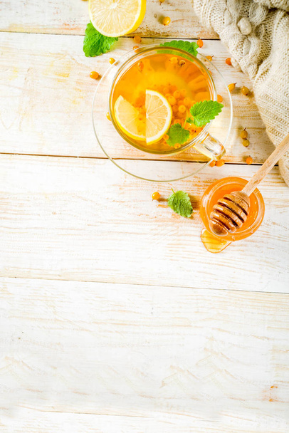 Σπιτικό buckthorn, κουμκουάτ, δυόσμο και μέλι τσάι ξύλινη φόντο αντίγραφο χώρου κάτοψη - Φωτογραφία, εικόνα