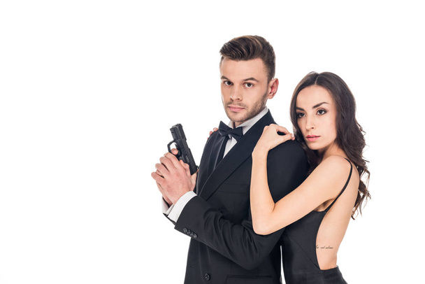beautiful woman embracing male secret agent with gun, isolated on white - Photo, Image