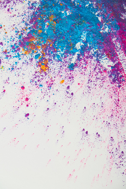 vista superior de la explosión de polvo de holi púrpura y azul sobre fondo blanco
 - Foto, imagen