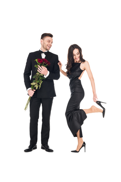 beautiful couple in black clothes posing with red roses on valentines day, isolated on white - Zdjęcie, obraz