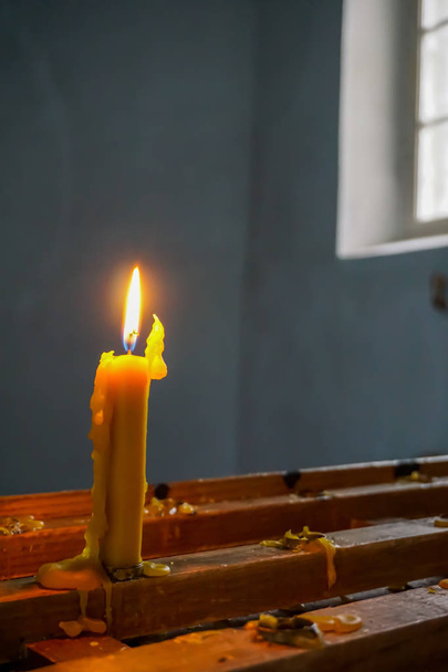 Brennende Kerze an der evangelisch-lutherischen Kirche in Koknese. Evangelisch-Lutherische Kirche in Koknese, Lettland. Innenraum der Kirche von Koknese. Kirche wurde 1687 erbaut.  - Foto, Bild