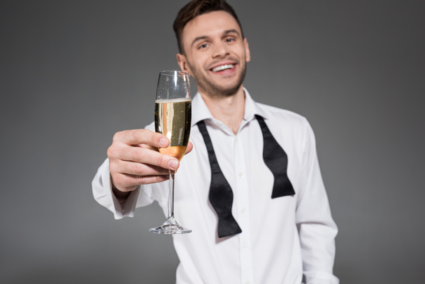 handsome cheerful man toasting with champagne glass isolated on grey - Foto, afbeelding