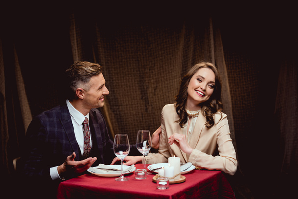 piękny szczęśliwa para siedzi przy stole podczas romantycznej kolacji w restauracji - Zdjęcie, obraz