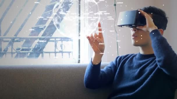 Animation young man sitting on the couch using virtual reality. Man making hand gestures to rotating globe with data connections. - Filmmaterial, Video